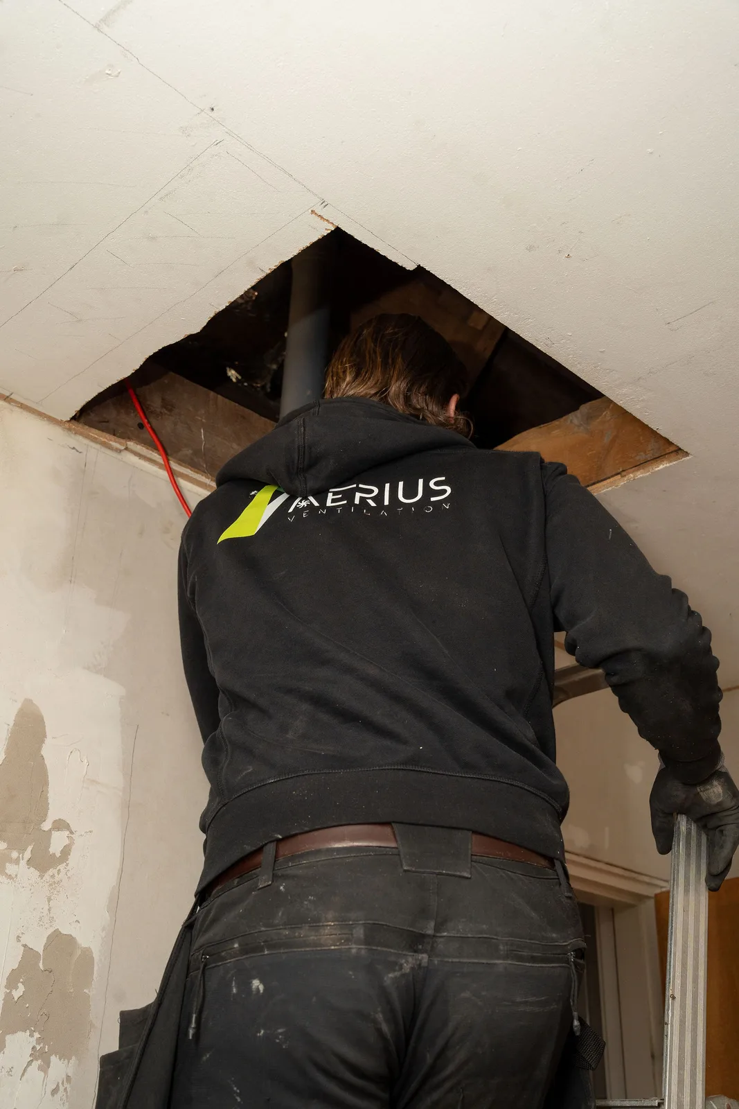 Tekniker från Aerius arbetar med ventilationen genom en öppnad lucka i taket, ett av de moment kontrollplanen följer upp