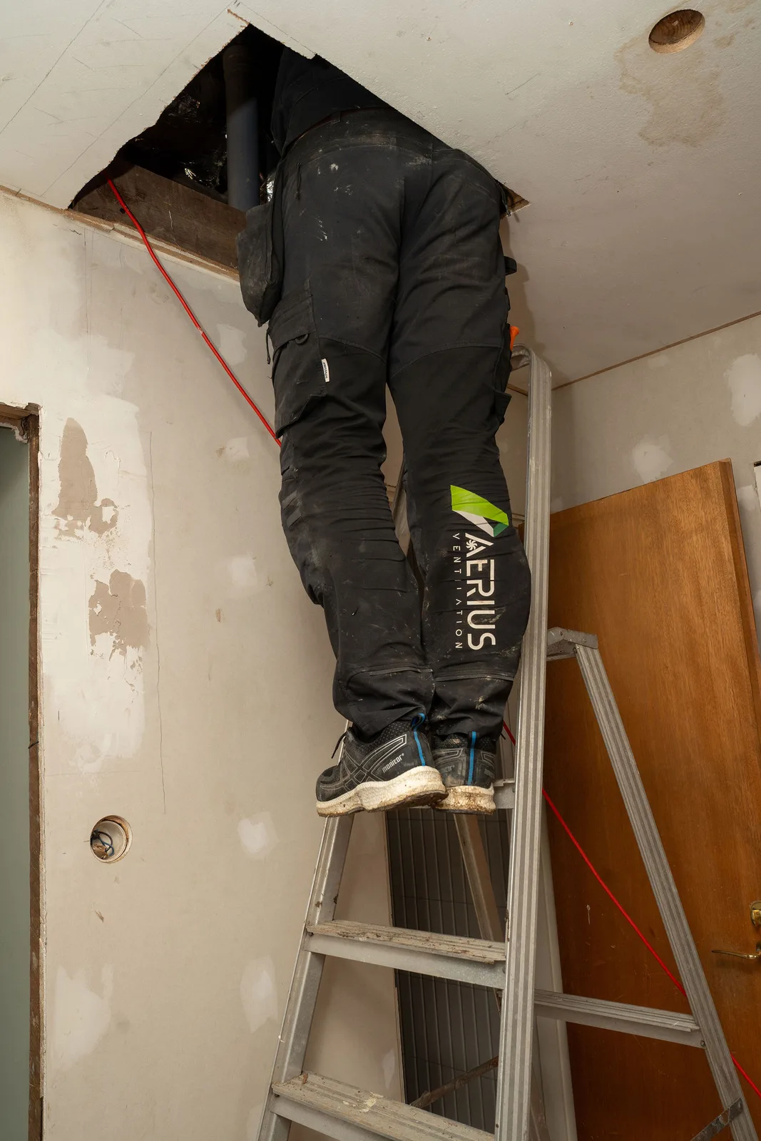 Tekniker från Aerius klättrar upp mot vinden inför byte av FTX-aggregat i ett hus i Tumba