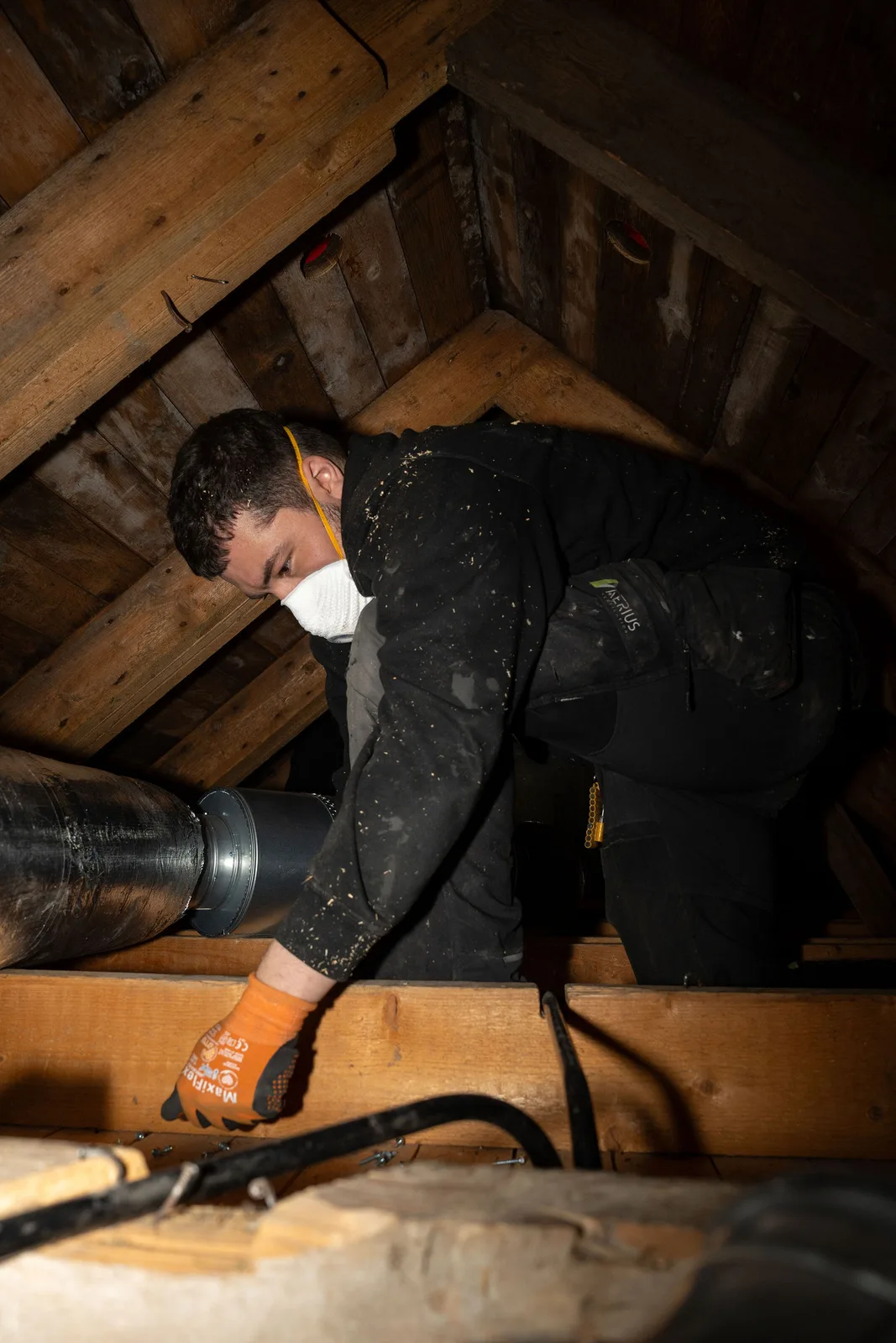 Montör från Aerius isolerar och ansluter ventilationskanaler på en vind under en FTX-installation i villa