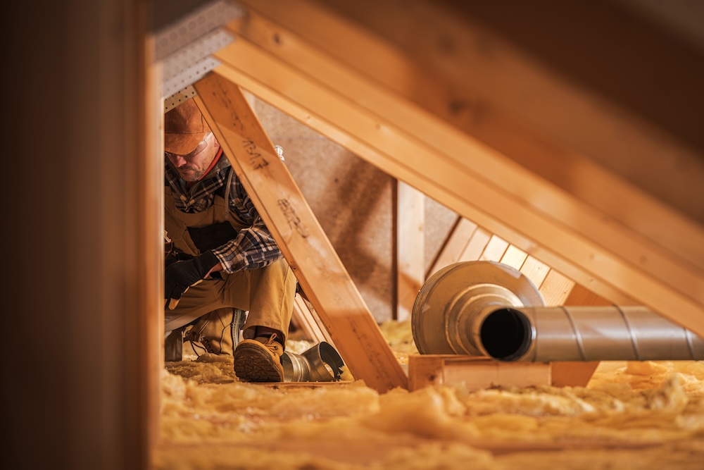 Ventilationstekniker jobbar med ventilation på vinden i en villa